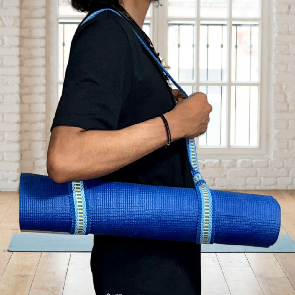 yoga mat strap is around a rolled up yoga bag and over the person's shoulder